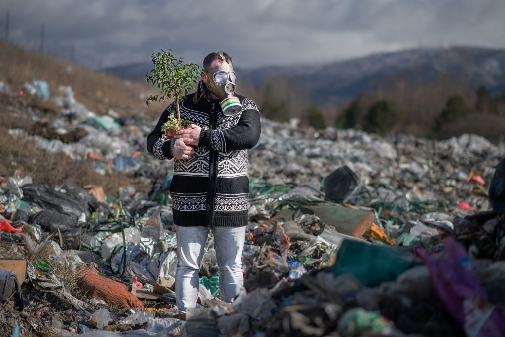 man with gas mask and plant on landfill environmen LMFYL9W общество UNDP, Александр Даррас, Грузия-ЕС, евросоюз, климат, Луиза Винтон, экология
