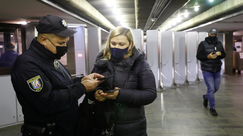 полиция проверяет наличие ковид-сертификата у женщины в метро в киеве