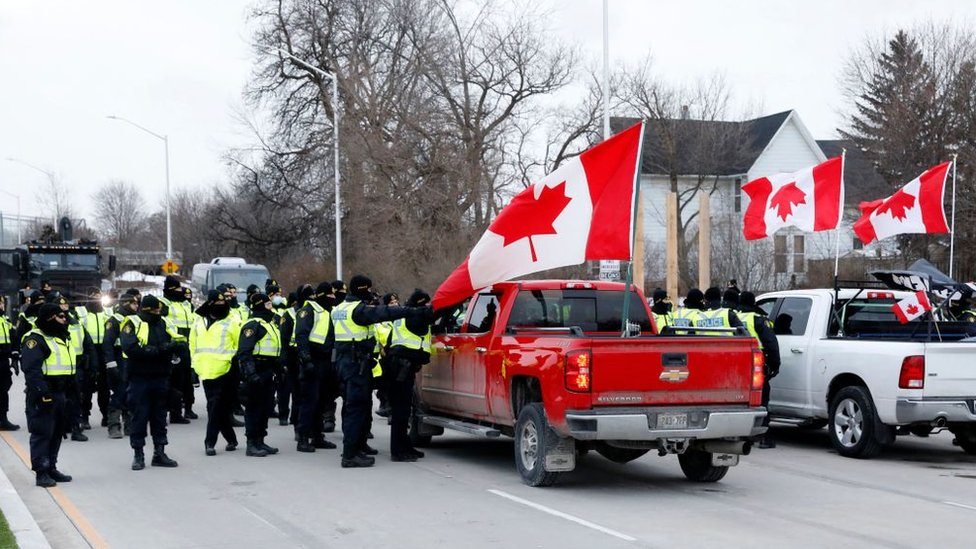 Грузовики с флагами Канады и полицейские