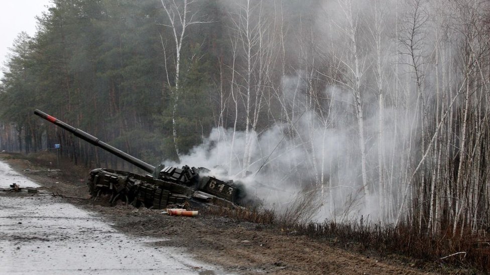 Дымящийся российский танк, подбитый украинскимисилами неподалеку от Киева