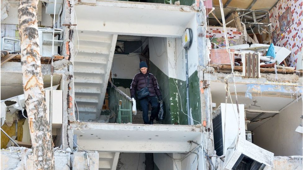 Мужчина выносит вещи из разрушенного при ракетном ударе жилого дома. Харьков, 13 марта