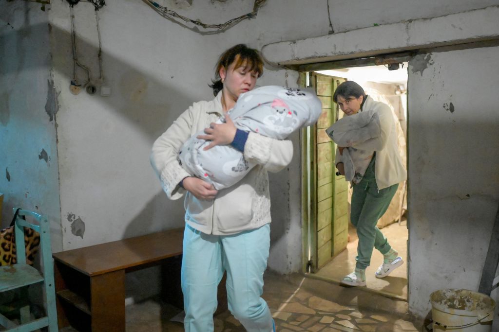 Медсестры несут младенцев в бомбоубежище в Николаеве