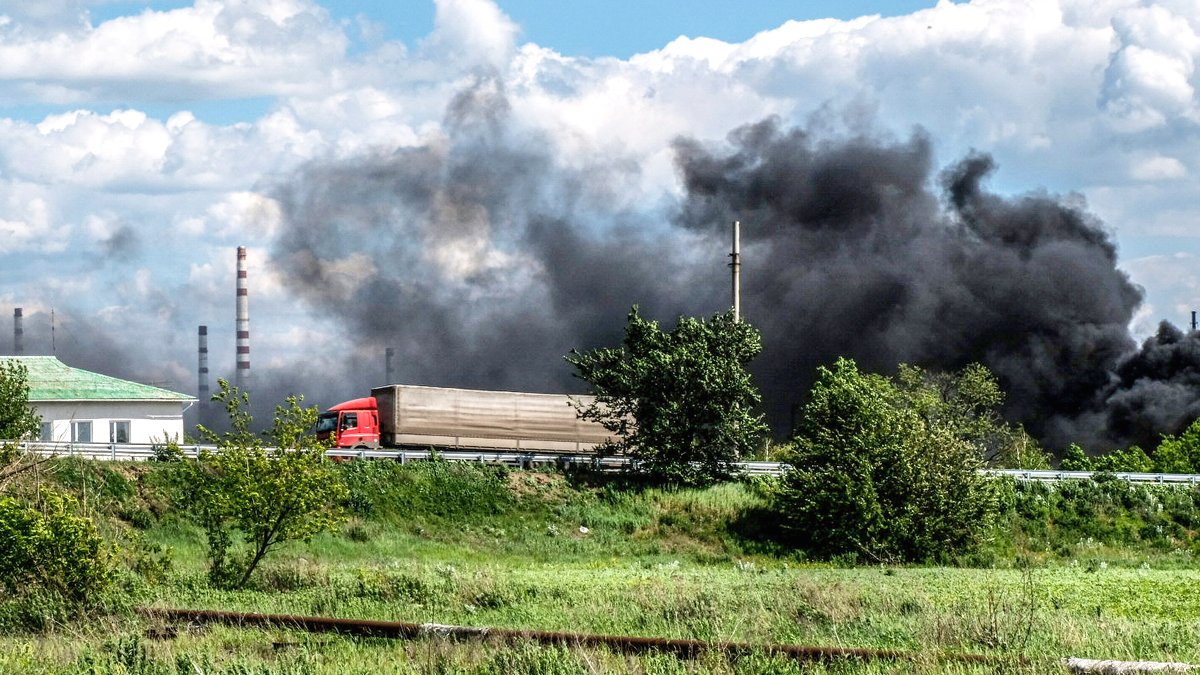 Клубы дыма над разбомбленным нефтеперерабатывающим заводом в Лисичанске 27 мая