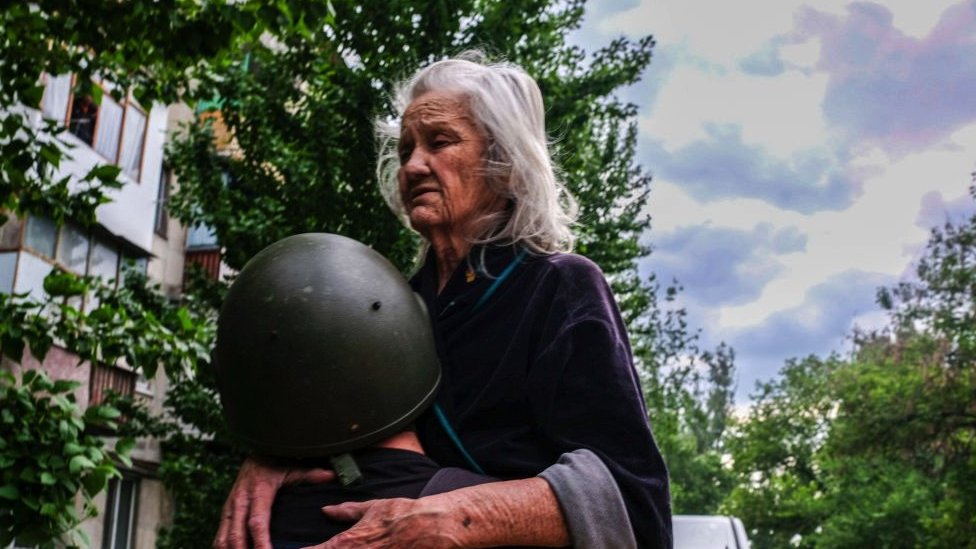 A volunteer carries the blind old woman to a van that will evacuate her out of the city. Severodonetsk, the largest city under Ukrainian control in Luhansk province, has come under intense artillery and missile strikes from the Russian army.