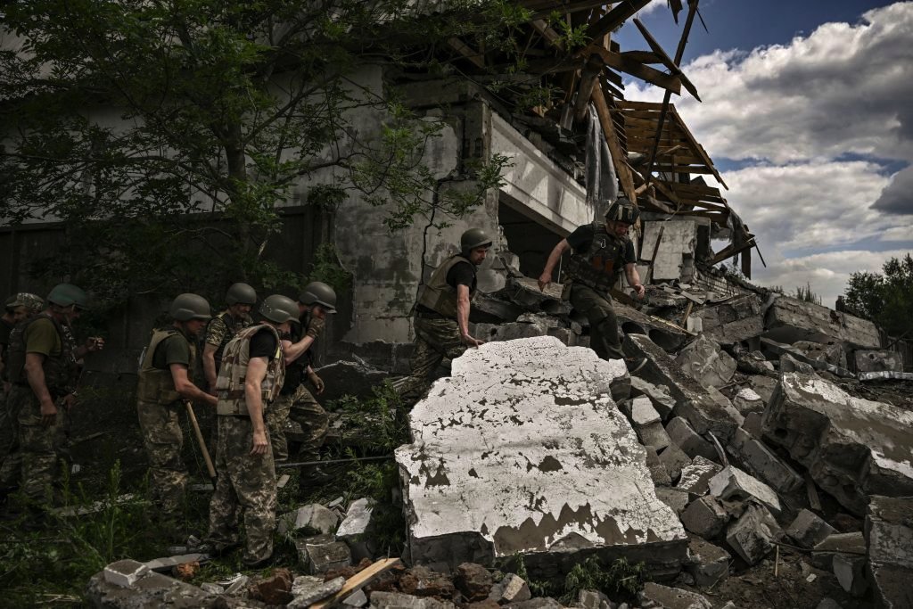 Ukrainian soldiers inspect a destroyed warehouse reportedly targeted by Russian troops on outskirts of Lysychansk, in the eastern Ukrainian region of Donbas on June 17, 2022, as the Russian-Ukraine war enters its 114th day