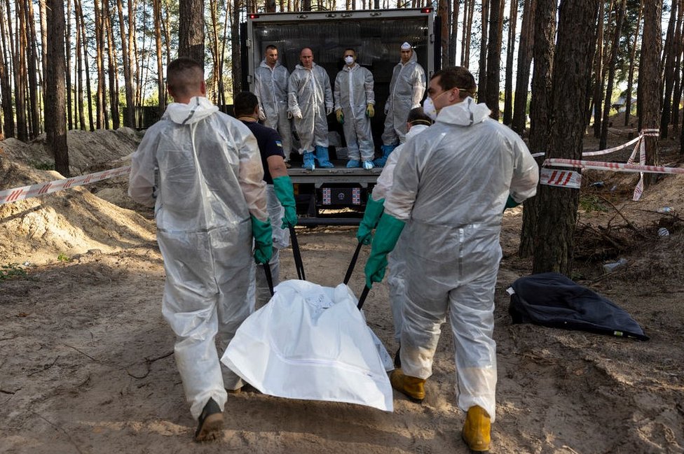 Украинские спасатели эксгумируют тела из братской могилы на окраине Изюма