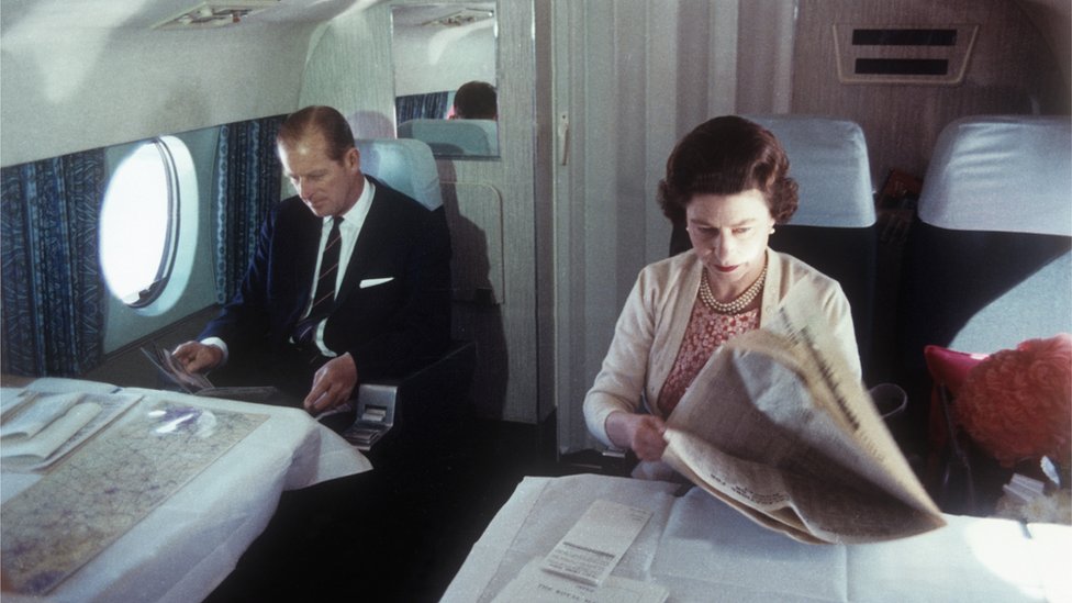 Принц Филипп и королева на борту самолета.
