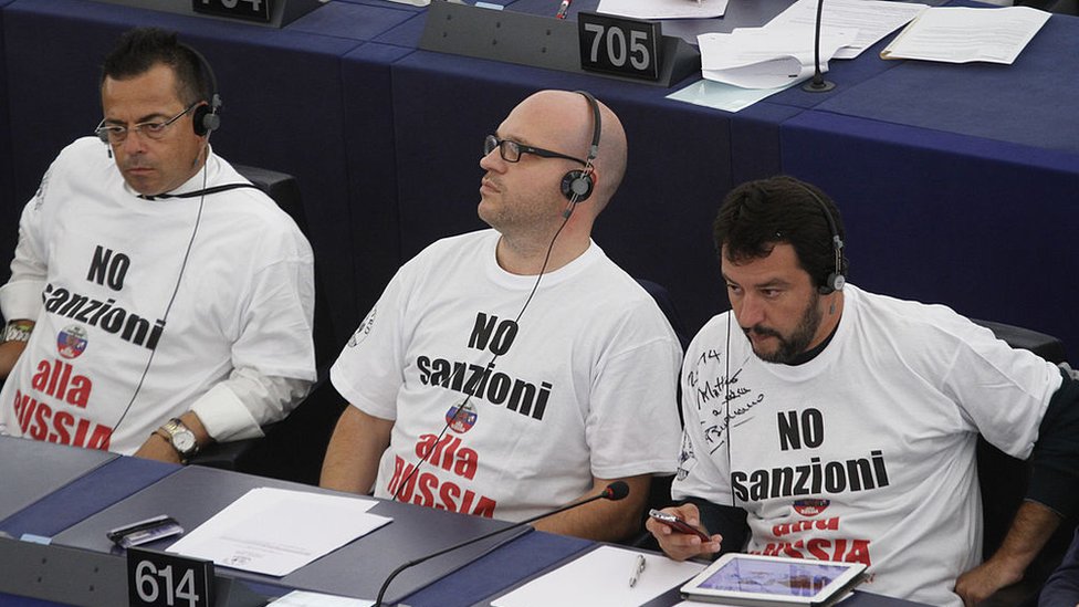 Лоренцо Фонтана (в центре) и Маттео Сальвини (справа) в футболках с надписью "Нет санкциям против России!" во время заседания Европарламента в сентябре 2014 года.
