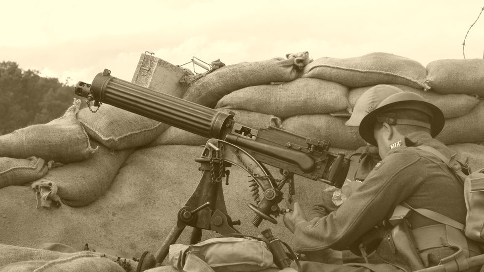 Пожелтевшая старая фотография британского солдата с ручным пулеметом в окопе