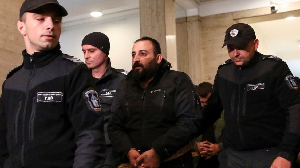 Полицейские сопровождают арестованного в здании суда в Софии