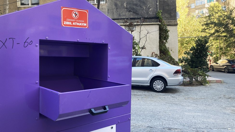 Фиолетовая коробка с просьбой бросать в нее только одежду, а не мусор