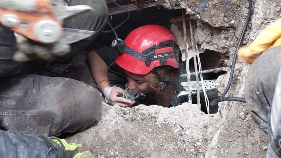 Женщину вытаскивают из-под обломков обрушенного здания