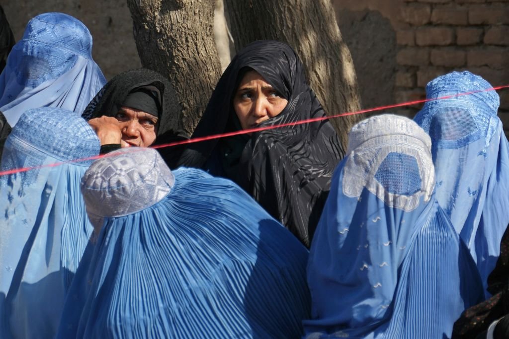 Женщины в паранджах в очереди за гуманитарной помощью