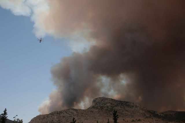 Пожарный вертолет над задымленной горой