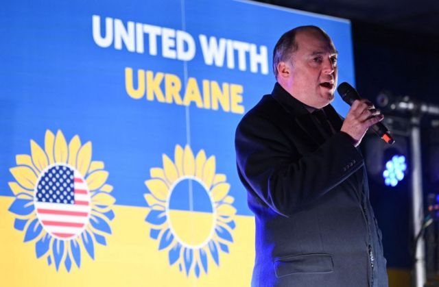 Бен Уоллес на фоне украинского флага
