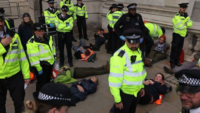 Лежащие на земле активисты и полицейские