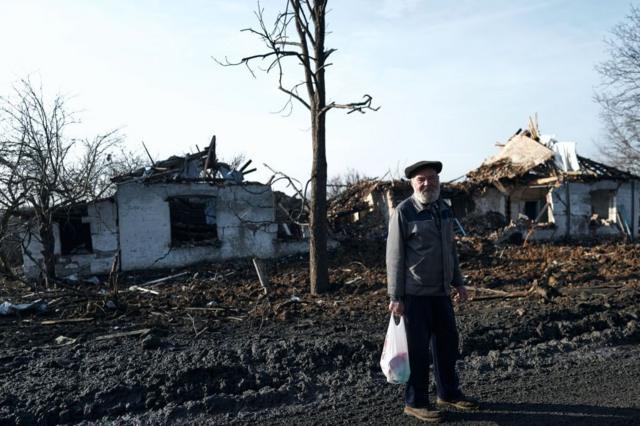 Мужчина на фоне разрушенных домов