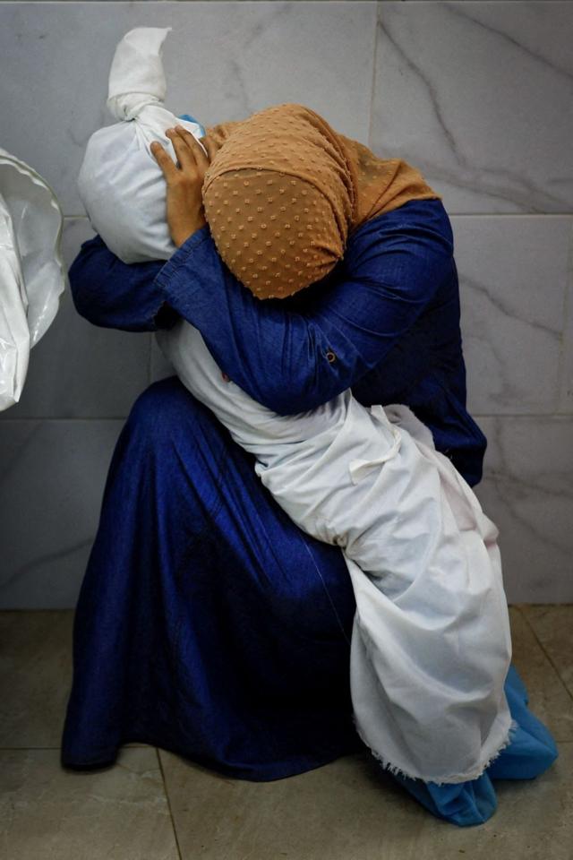 Инас Абу Мааамар держит в руках тело своей племянницы Сали