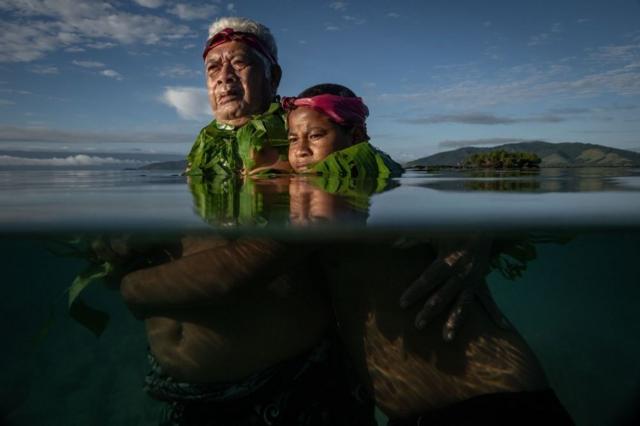Старейшина общины, 72-летний Лотомау Фиафиа вместе со своим внуком Джоном в заливе на острове Киоа на Фиджи