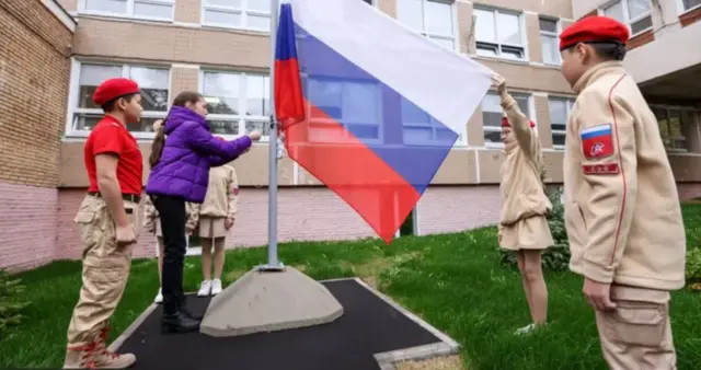 дети поднимают флаг в школе